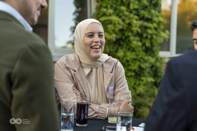 Een lachende gast in gesprek aan een tafel