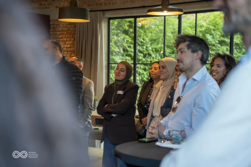 Een groep gasten in gesprek bij het raam